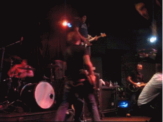 Гифка Рок-музыкант раскручивает гитару на сцене