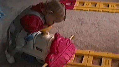 Гифка Ребёнок уснул на игрушечной железной дороге